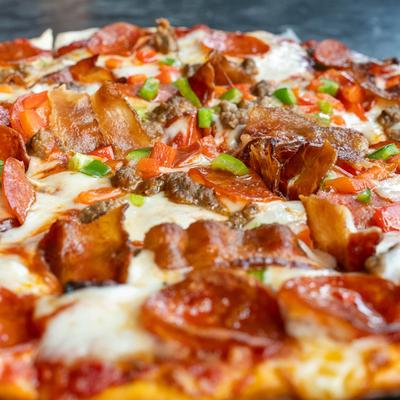 A fully loaded meat and vegetable pizza.