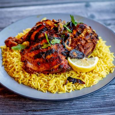 Half chicken rubbed with spices and served over rice.