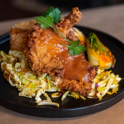 Fried chicken on a bed of coleslaw, served with rice.