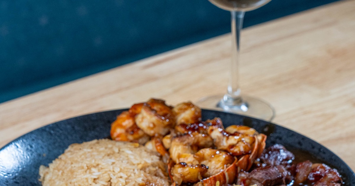 Hibachi Trio Special with sides, served on the table with a glass of red wine