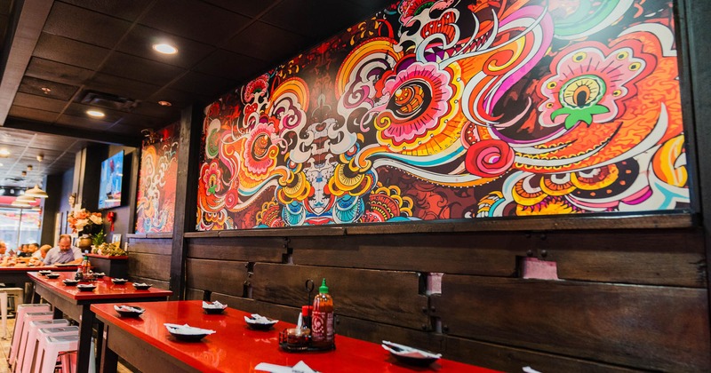 Restaurant interior with a long red counter with white stools