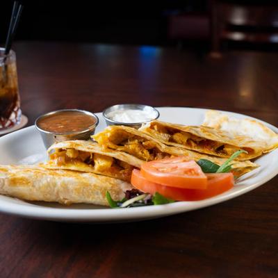 Chicken quesadilla served with salsa and sour cream.