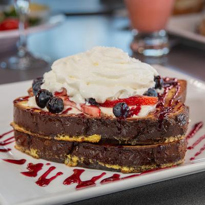 Stuffed French toast topped with whipped cream and berries.