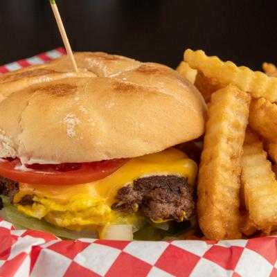 Cheeseburger with crinkle-cut fries on checkered paper.