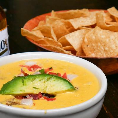 Queso dip with avocado and tortilla chips.