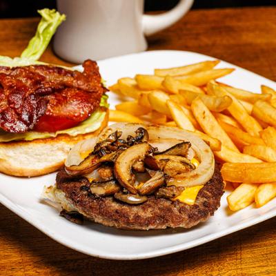 Bacon cheeseburger with mushrooms, grilled onions, lettuce, tomato, and fries.