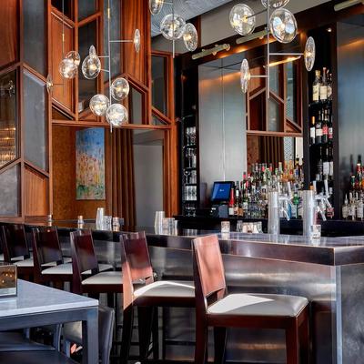 Bar area with metalic coynter, stools and unique pendant lighting.