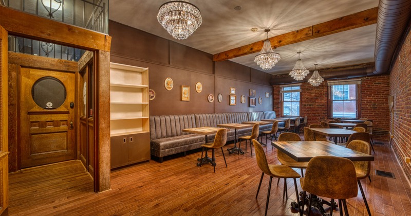 Interior, dining area, long banquette bench with tables and chairs, regular tables, red brick walls