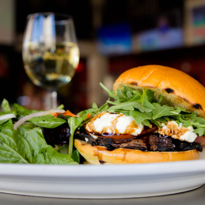 Beef sandwich, with BBQ sauce, cheese, tomato and arugula, with salad on the side photo.