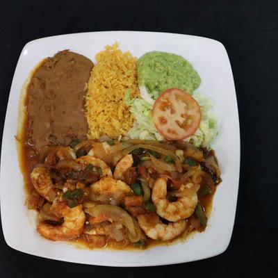 Shrimp fajitas with sides of refried beans, Mexican rice and guacamole.
