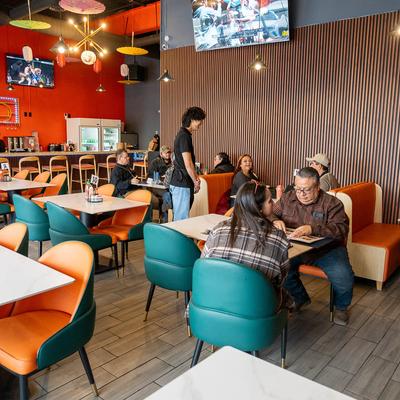 Vibrant interior, guests seated at booths and tables.