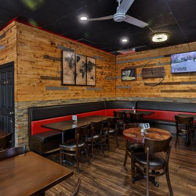 Interior with wood-paneled walls, booth seating and multiple televisions.