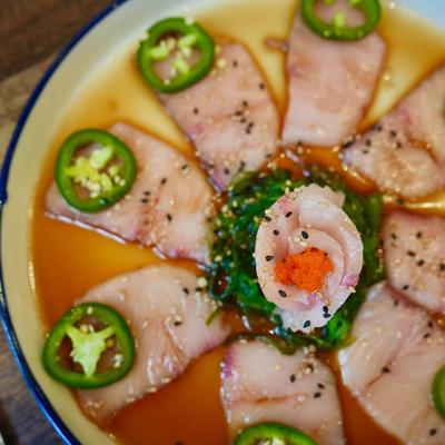 Yellow tail sashimi with jalapeno and seaweed.