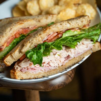 A closeup on a sandwich with ham, turkey, and Swiss cheese.