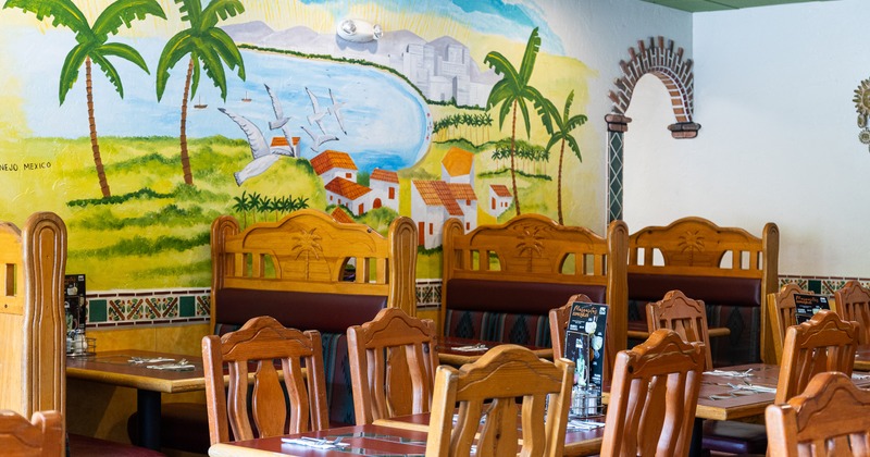 Dining area of a Mexican-style restaurant with wooden tables and chairs