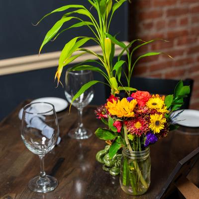 Flowers, glasses, and plates on the table.