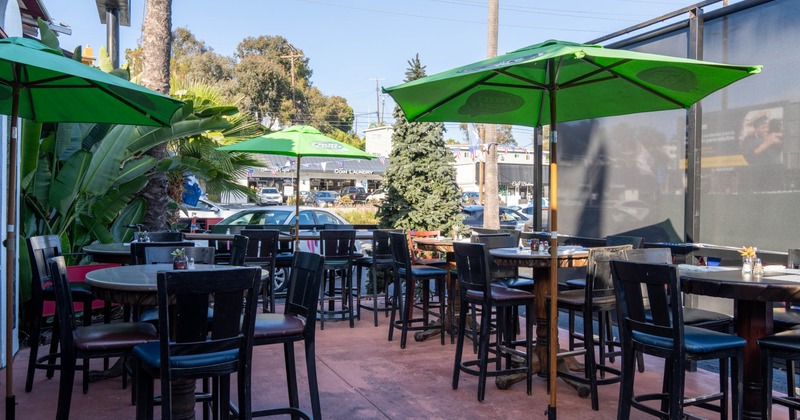 Exterior, partially covered seating area, tables and chairs under parasols