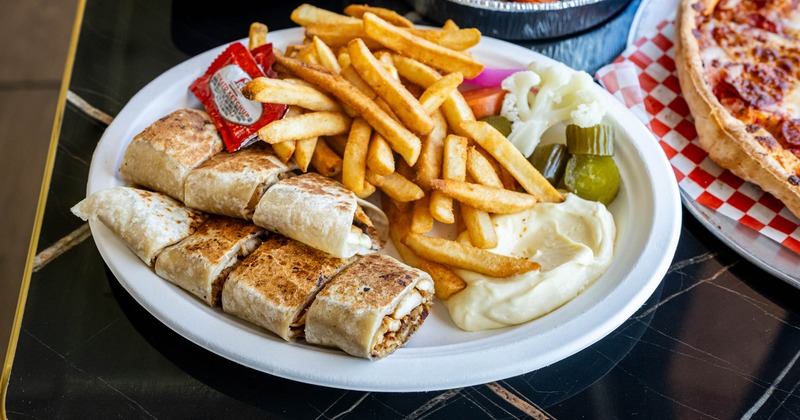 Chicken shawarma wrap with fries, vegetables, and garlic sauce