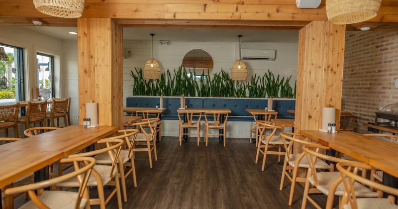 Interior, wooden tables and chairs, banquette seating in the back