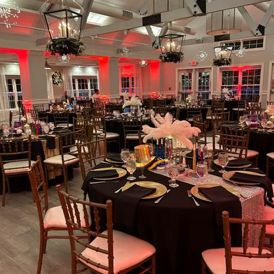 Fully set round tables with black tablecloth.