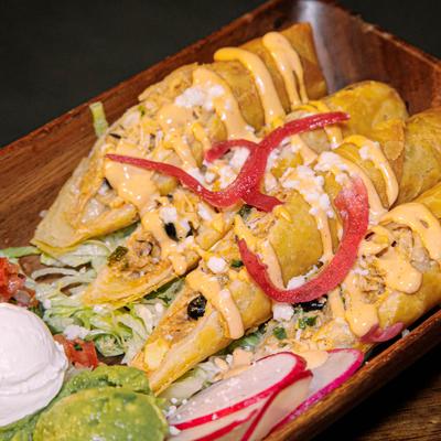 Chicken Flautas, with corn, black beans, cheese, pico, sour cream, and guacamole.
