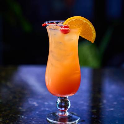 Georgia Peach cocktail served in a hurricane glass with cherry and lemon slice garnish.