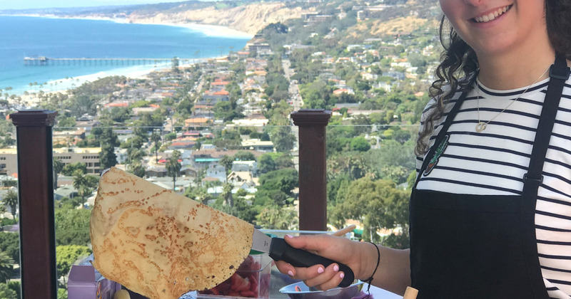 Employee flipping a pancake with a picturesque view in the back