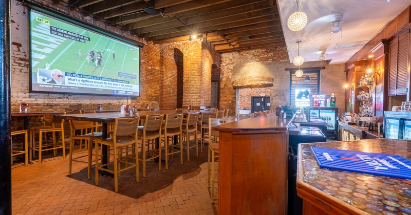 Interior,  seating area with tables and chairs in front of the bar