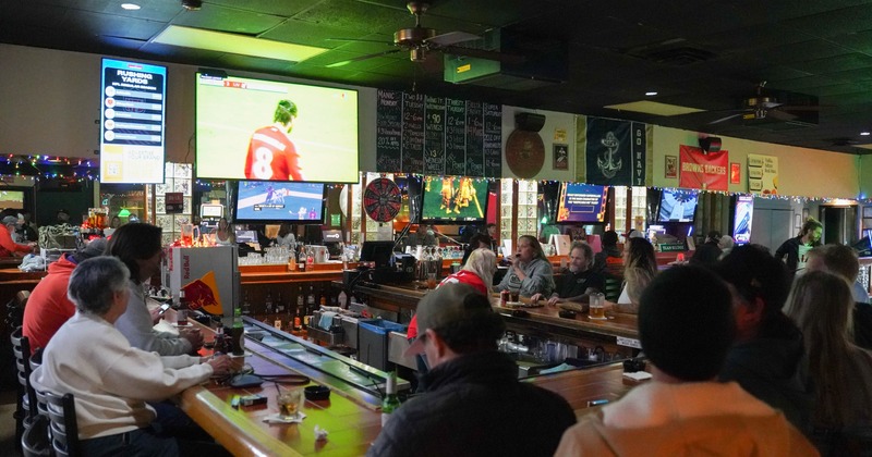 Bar, people around, tv screens