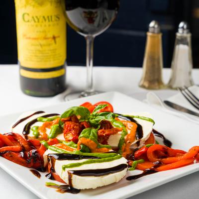 Caprese salad topped with balsamic drizzle and fresh basil.