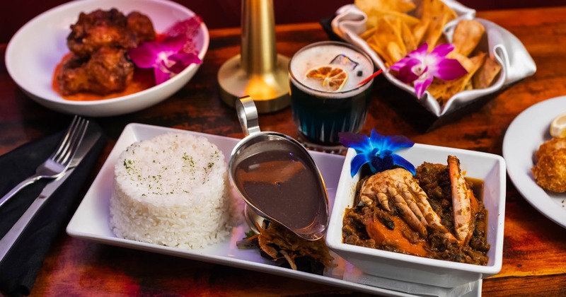 Seafood Legume served with rice, tortilla chips, and a cocktail