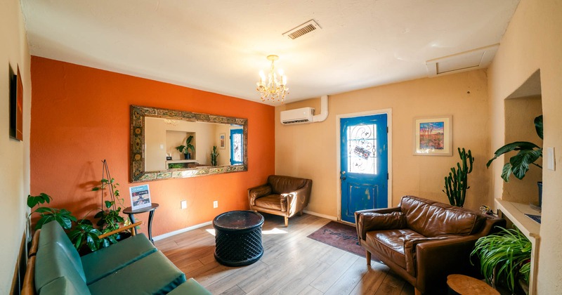 Living room with leather furniture, blue front door, and potted plants
