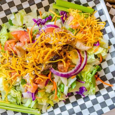 Chef salad, with lettuce, celery, onions, green peppers, cheddar, and boiled egg.