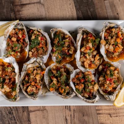 Steamed oysters topped with a mixture of vegetables and herbs.