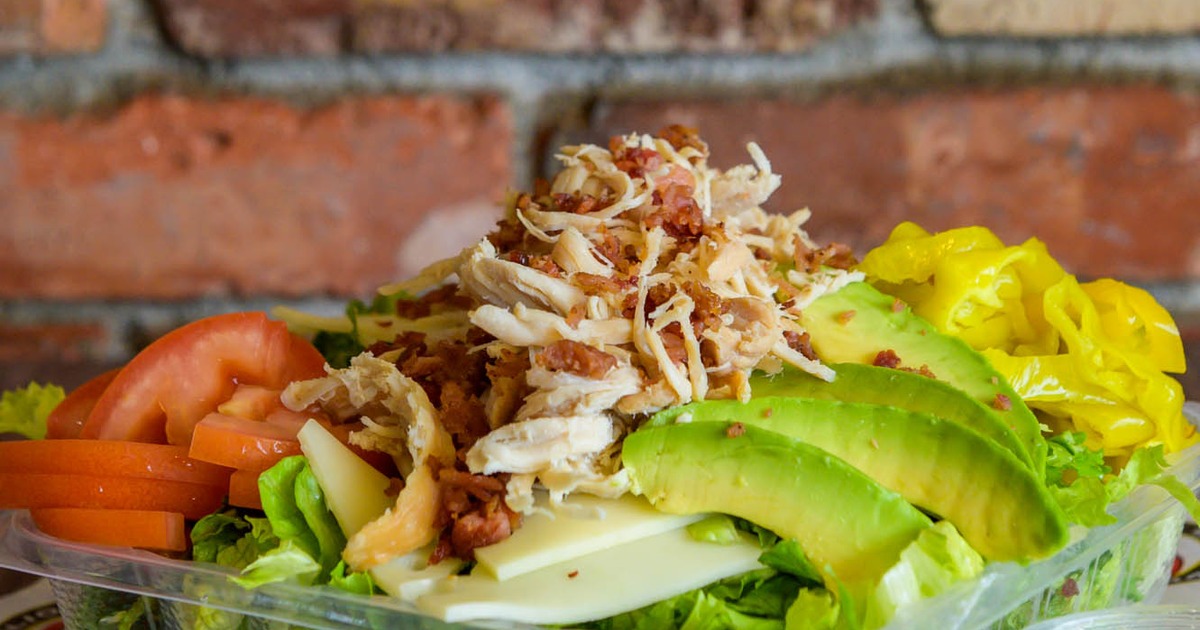 Salad with turkey, bacon, lettuce, pepperoncini, tomato, and avocado
