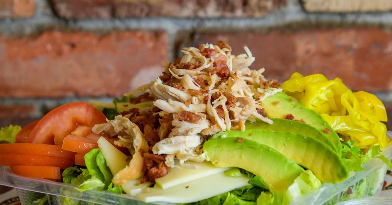 Salad with turkey, bacon, lettuce, pepperoncini, tomato, and avocado