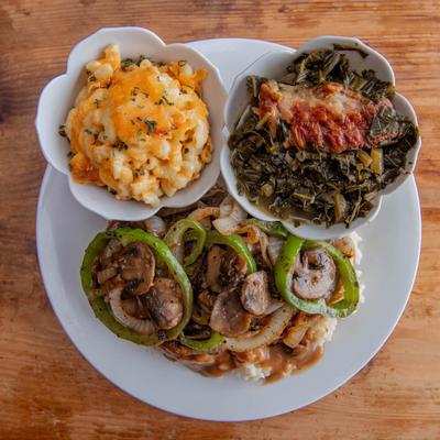 Hamburger steak with macaroni and cheese and collard greens.