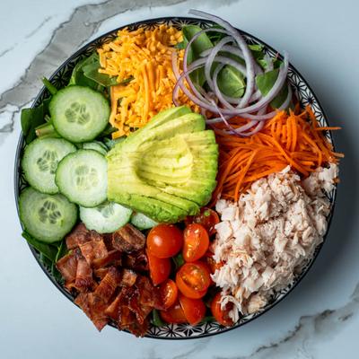 A salad with turkey, bacon, avocado and other ingredients.