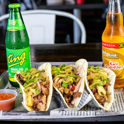 Three chopped tacos served with sparkling beverages.