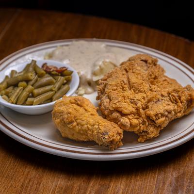 Fried chicken with sides of green beans and biscuit with gravy.