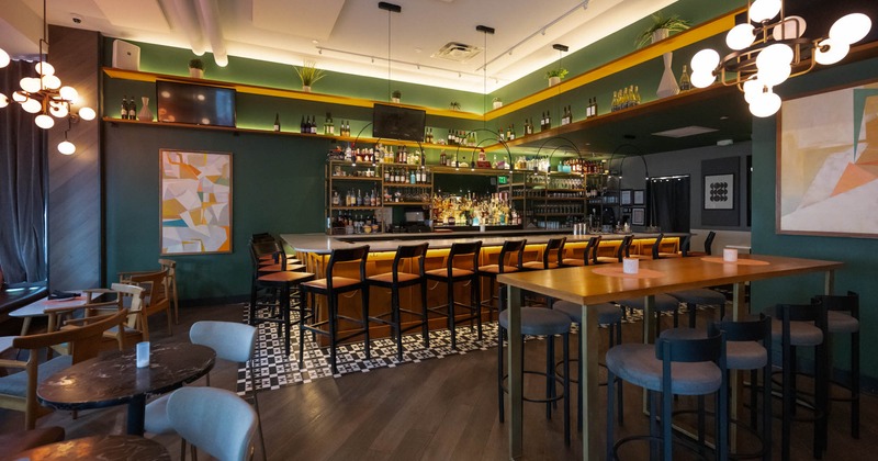 Interior with a well-stocked bar, tables, and wall art