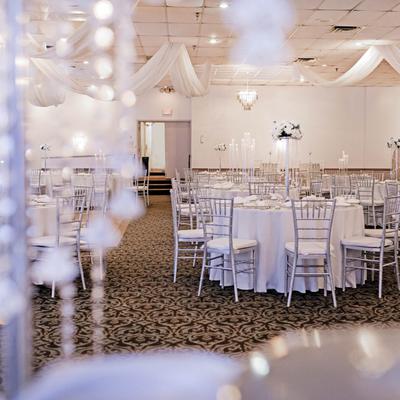 Wedding reception hall decorated with white drapes.