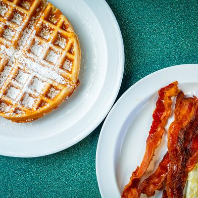 Eggs and bacon with a waffle on the side.