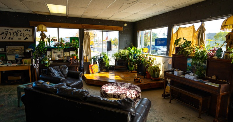 Lounge area with leather sofa and chair, piano, and plant decoration