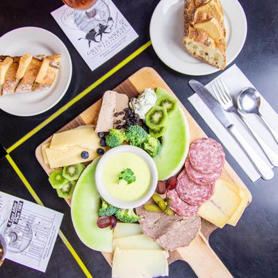 An assortment of cold cuts, cheese, bread and vegetables with a glass of iced tea