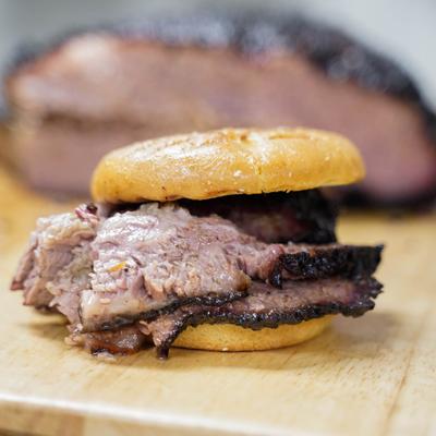 A BBQ brisket sandwich on a wooden board.