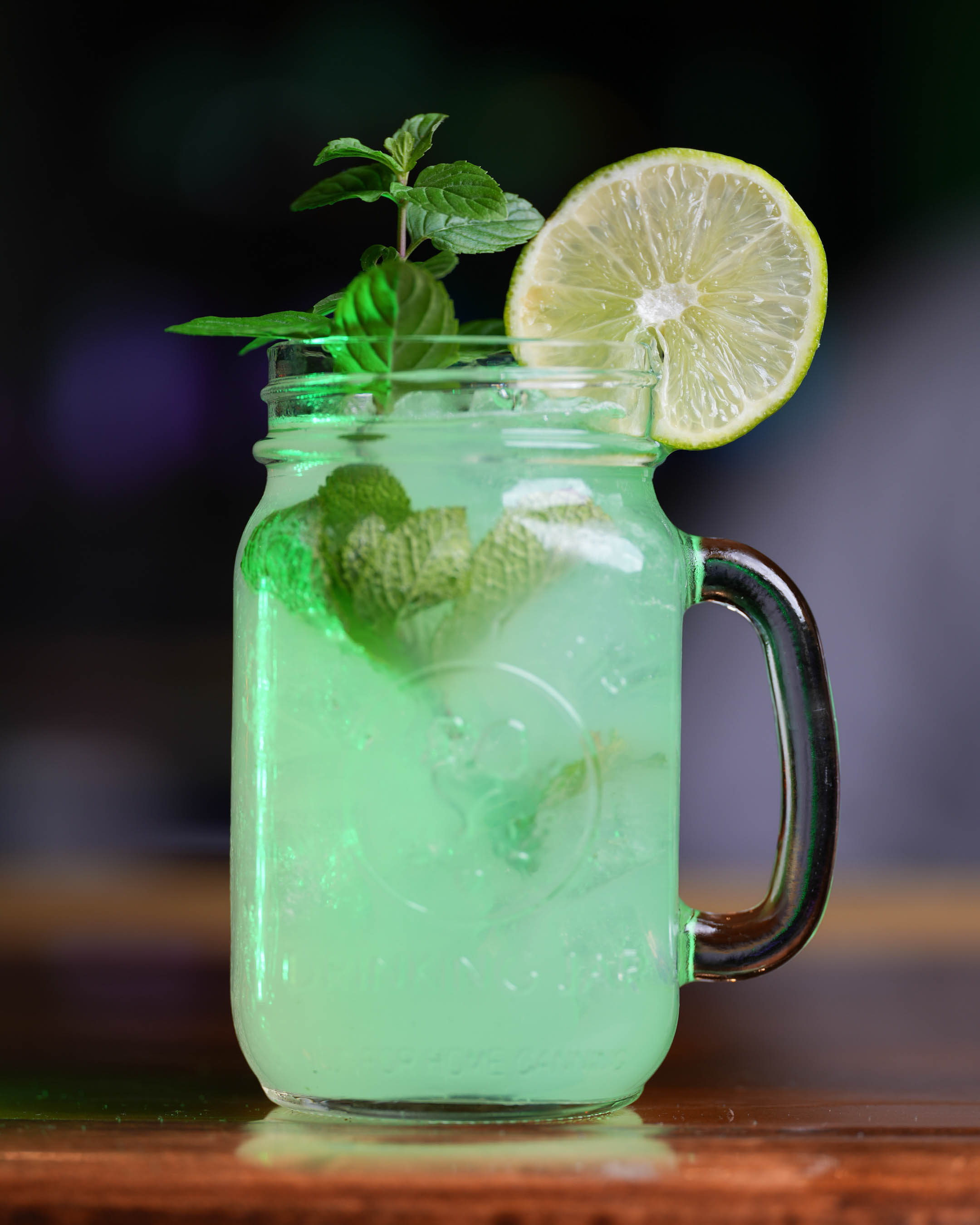 Cocktail srved in a mug, garnished with mint spring and lime wheel