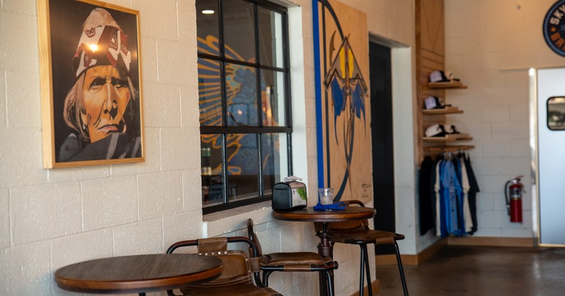 Interior, coffee tables, arnchairs by wall and window, merch corner