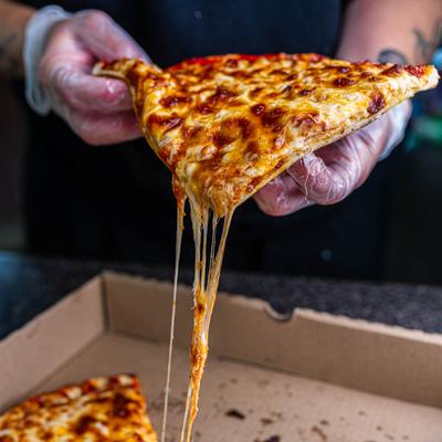 Cheese pull shot of a cheese pizza slice.