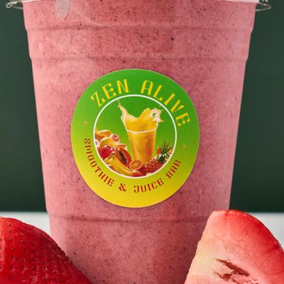 Strawberry Pina Colada served in a plastic cup alongside fresh strawberries.